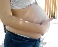 Daughter poking at mom's pregnant belly